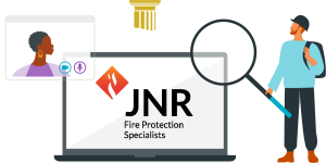 Illustration of a man with a magnifying glass inspecting a laptop screen showing the "JNR Fire Protection Specialists" logo and a video call window.